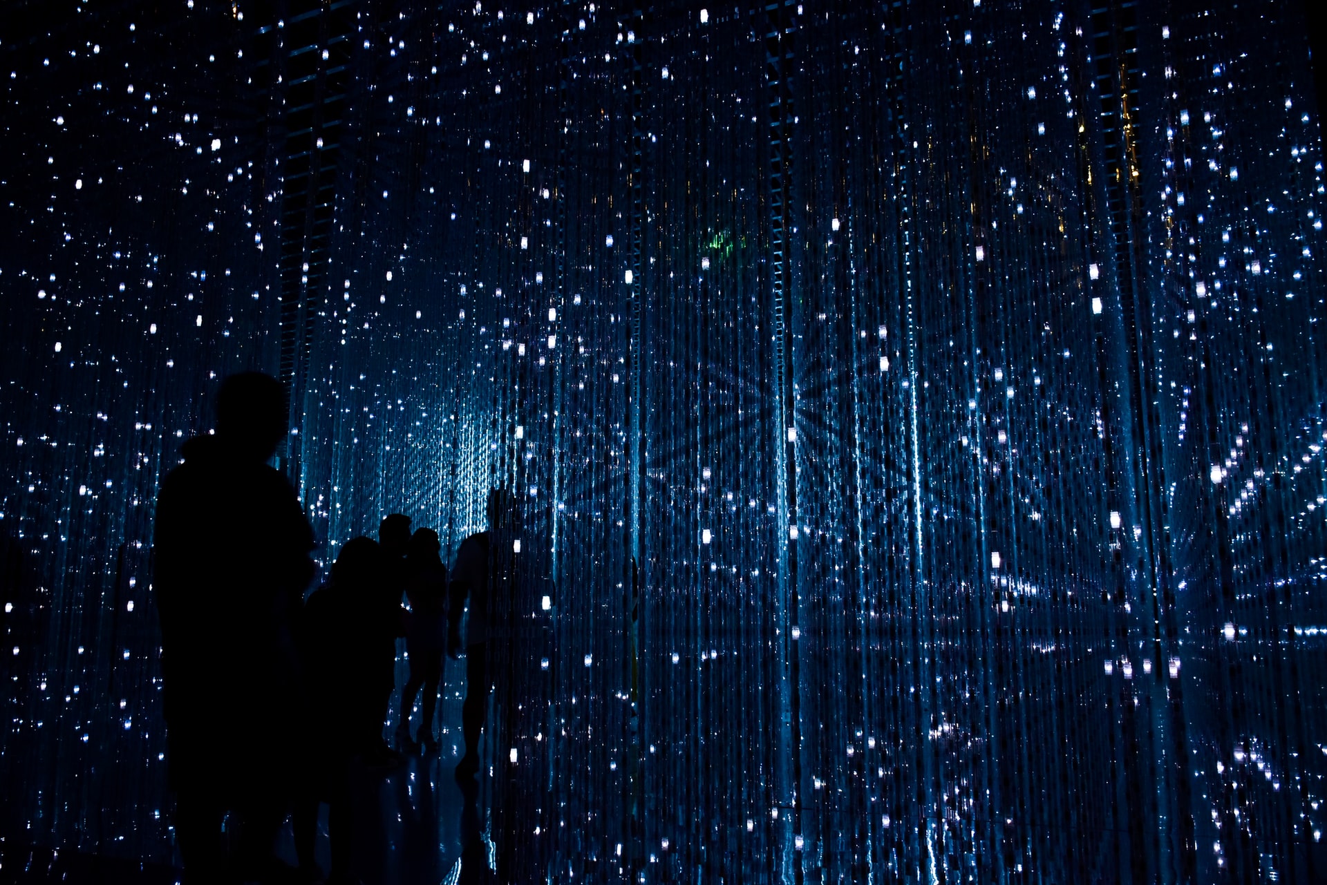 mensen in donkere kamer met abstracte lichtpatronen
